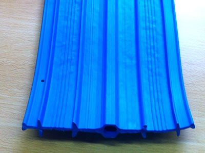 A strip of blue ribbed with center bulb PVC waterstop is on the table.