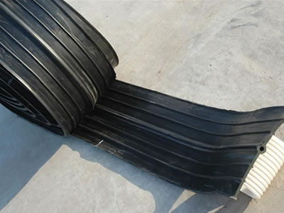A roll of rubber waterstop is on the ground.