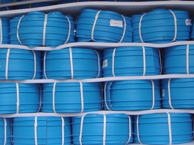 Many rolls of blue PVC waterstops are piled on the ground.
