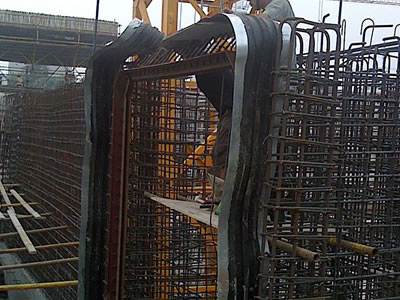 A steel-edge waterstop is installed to steel reinforcing bars by a person.